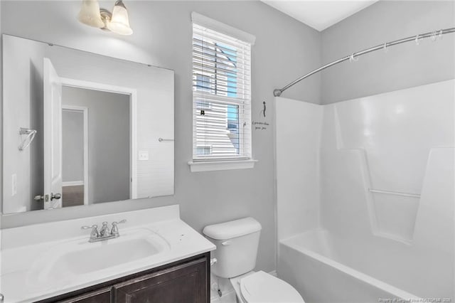 bathroom featuring toilet, vanity, and bathing tub / shower combination