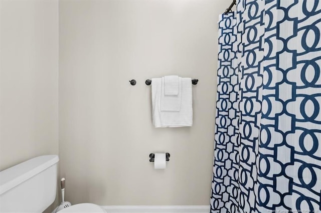 full bathroom featuring toilet and a shower with shower curtain