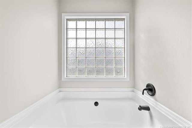 full bath featuring a garden tub and a wealth of natural light