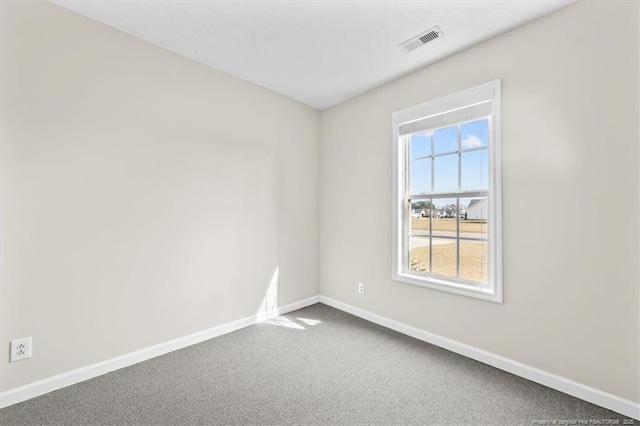 spare room featuring visible vents, carpet, and baseboards