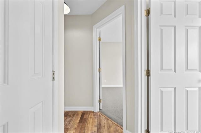 hallway featuring baseboards and wood finished floors