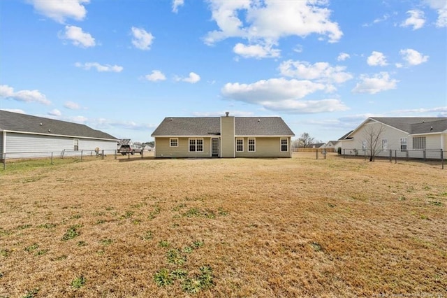 rear view of property featuring a lawn and a fenced backyard