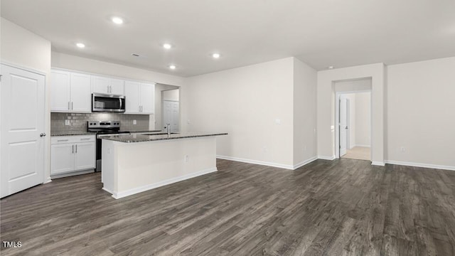 kitchen with tasteful backsplash, dark wood-type flooring, appliances with stainless steel finishes, white cabinets, and a kitchen island with sink