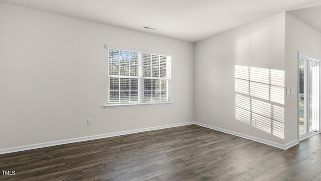 unfurnished room featuring visible vents, baseboards, and dark wood-style flooring