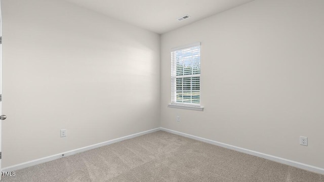 unfurnished room featuring visible vents, light carpet, and baseboards