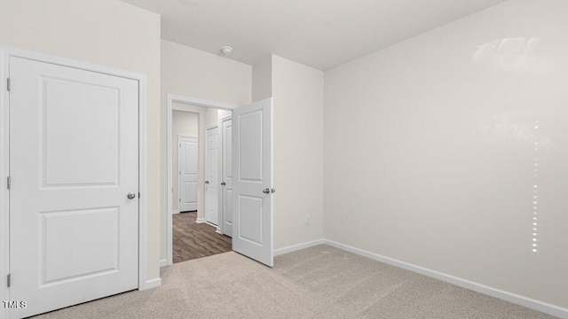 unfurnished bedroom with carpet flooring and baseboards