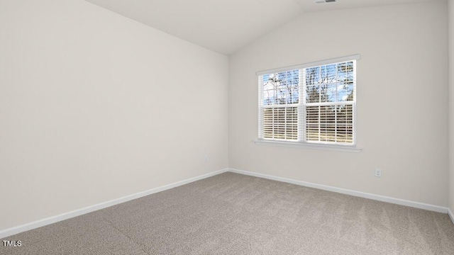 carpeted empty room featuring vaulted ceiling, visible vents, and baseboards