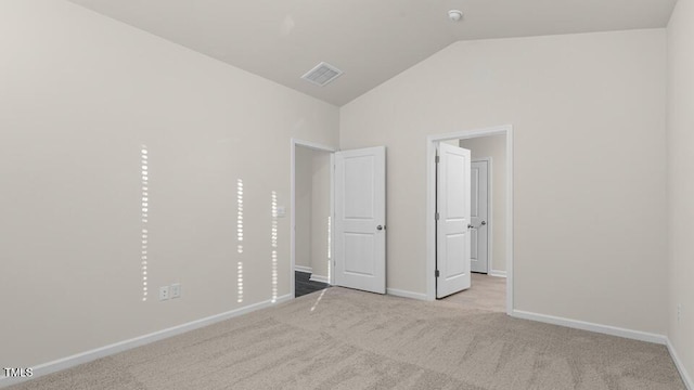 unfurnished bedroom with visible vents, lofted ceiling, baseboards, and carpet flooring