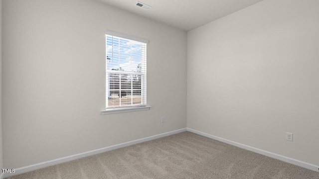 carpeted spare room featuring visible vents and baseboards