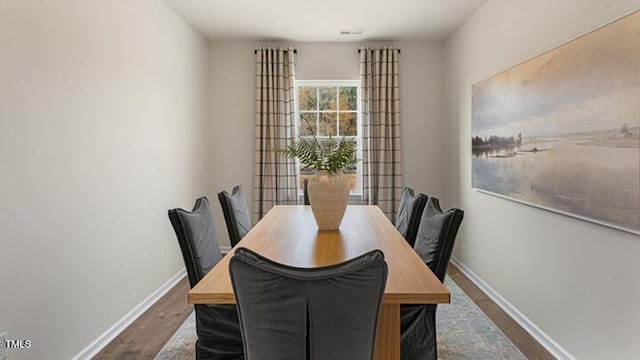 dining area with visible vents, baseboards, and dark wood finished floors