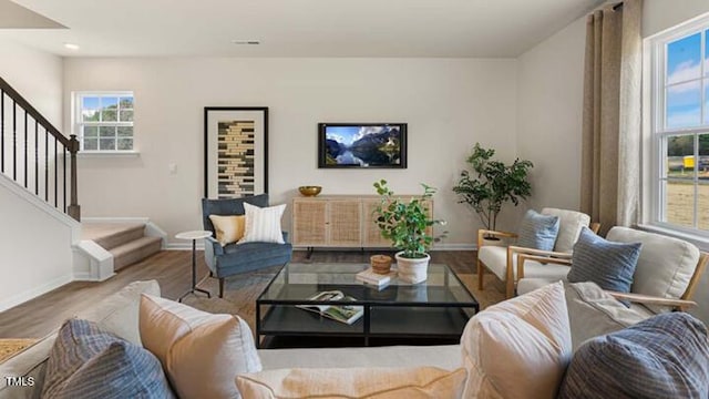 living room with recessed lighting, stairway, baseboards, and wood finished floors