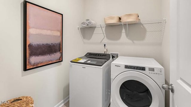 laundry room featuring baseboards, separate washer and dryer, and laundry area