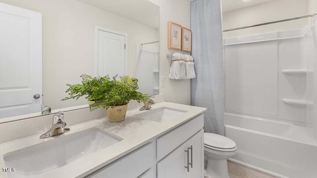 full bathroom with double vanity, toilet, shower / tub combo with curtain, and a sink