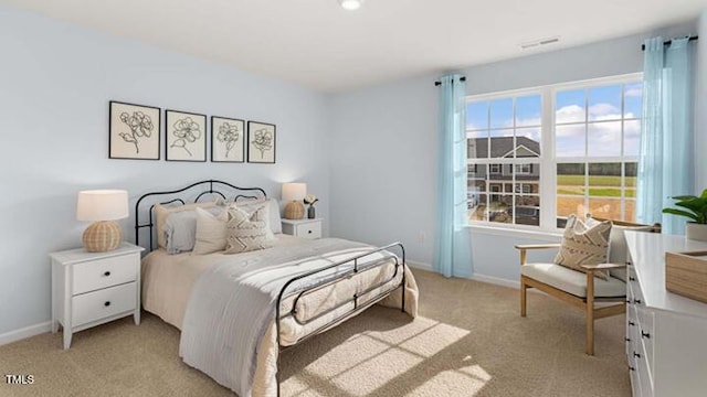 bedroom with light colored carpet and baseboards