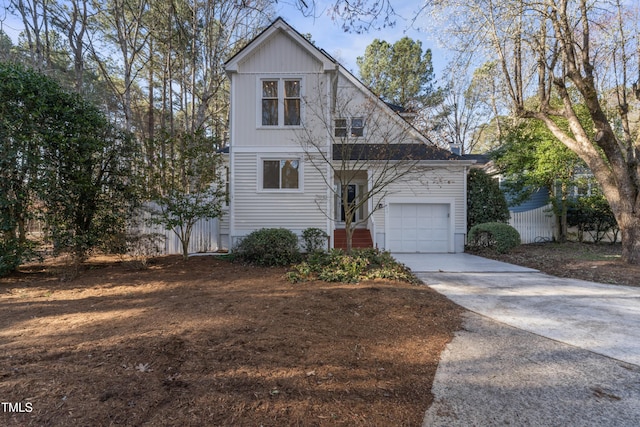 view of front of house featuring concrete driveway, a garage, and fence