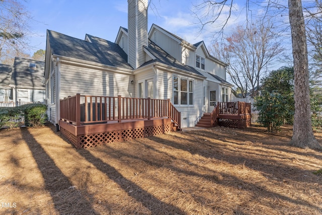 rear view of house featuring a wooden deck and a chimney