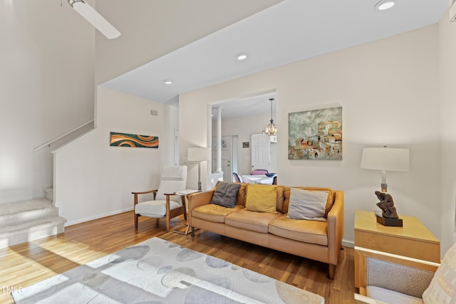 living room with recessed lighting, baseboards, wood finished floors, and stairs