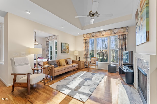 living area featuring recessed lighting, a fireplace, ceiling fan, vaulted ceiling, and light wood-style floors