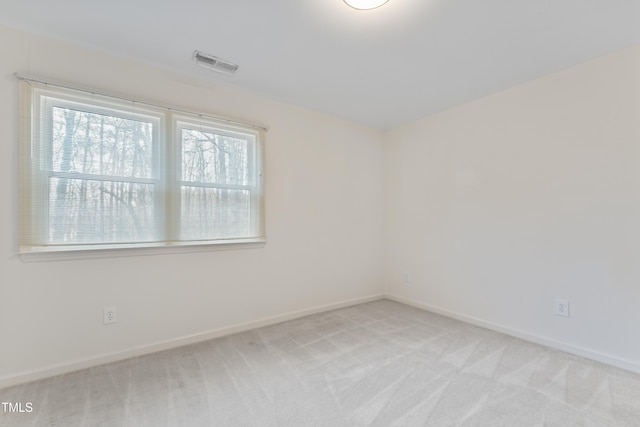 unfurnished room featuring visible vents, baseboards, and light colored carpet