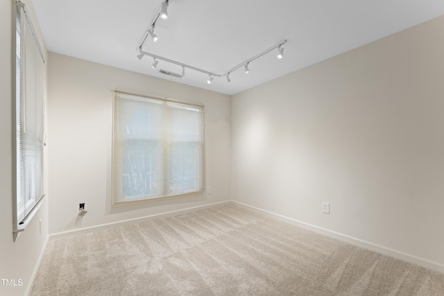 spare room featuring visible vents, baseboards, and carpet