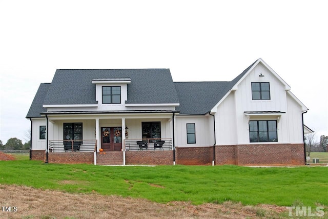 modern farmhouse style home with a porch, board and batten siding, brick siding, and a front lawn