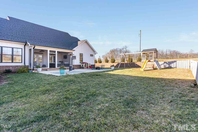 view of yard with a patio area, a playground, and fence