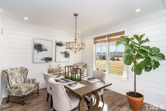 dining space with crown molding, a notable chandelier, wood finished floors, and recessed lighting