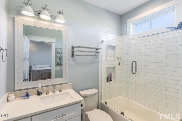 full bathroom featuring toilet, vanity, and shower / bath combination with glass door