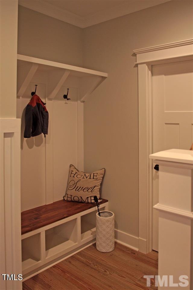 mudroom with baseboards, wood finished floors, and crown molding