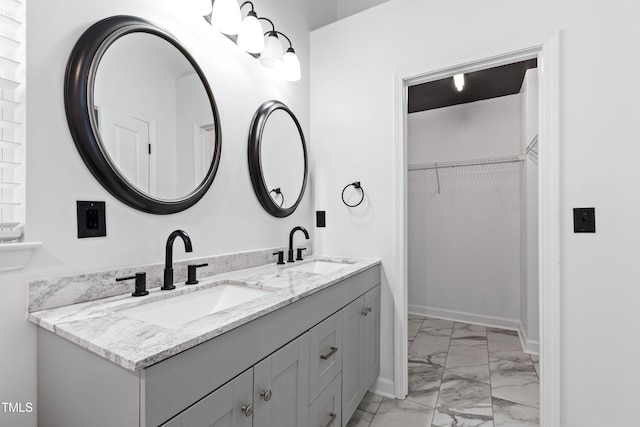 717 Samuel Cary Dr, Cary, NC 27511 - bathroom with marble finish flooring, double vanity, a walk in closet, and baseboards