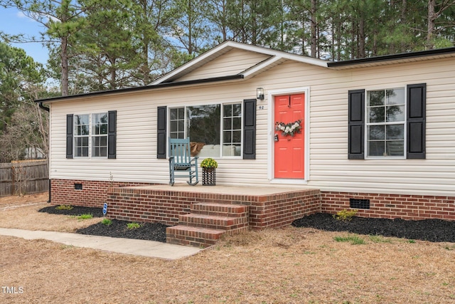 view of front of property with crawl space, covered porch, and fence