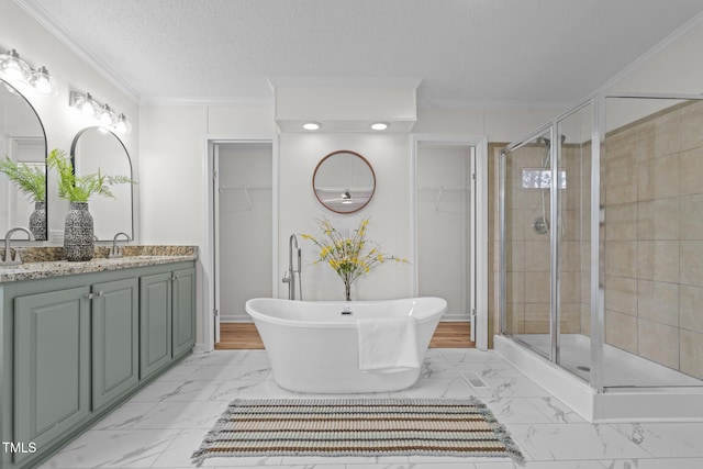 bathroom with crown molding, marble finish floor, a shower stall, and a textured ceiling