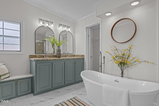 bathroom with a textured ceiling, crown molding, double vanity, and a sink