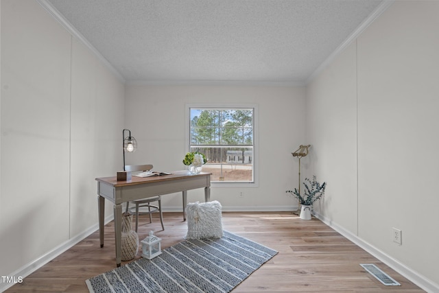 office space with visible vents, a textured ceiling, crown molding, and wood finished floors