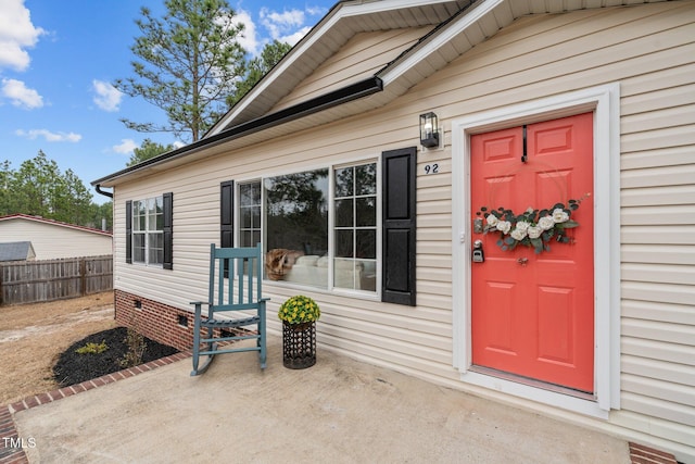 property entrance featuring fence and crawl space