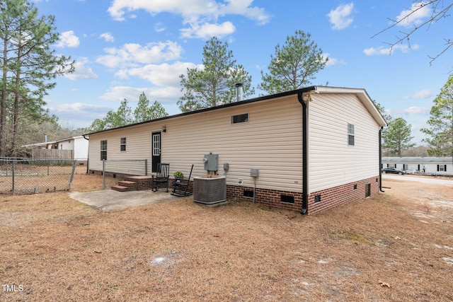 back of house with crawl space, central AC, and fence