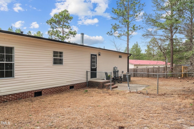 rear view of house with crawl space, a patio area, central AC unit, and fence