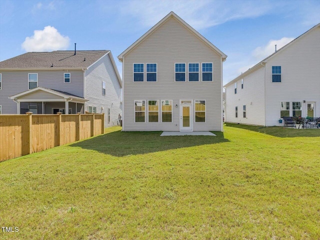 back of property with a yard and a patio area