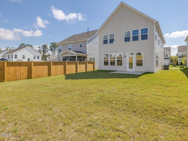 rear view of house with cooling unit, fence, and a lawn