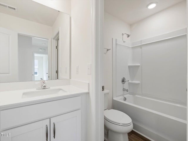 bathroom with vanity, wood finished floors, visible vents, shower / tub combination, and toilet