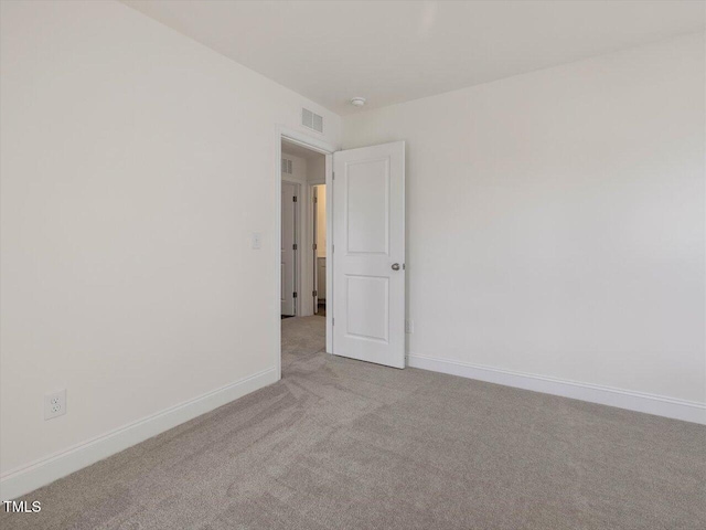 empty room with visible vents, carpet floors, and baseboards