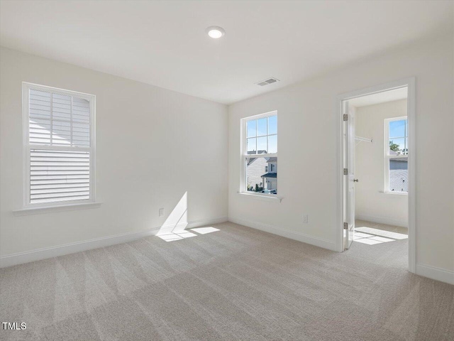 spare room with visible vents, baseboards, and carpet flooring