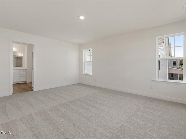 unfurnished room featuring recessed lighting, light colored carpet, and baseboards