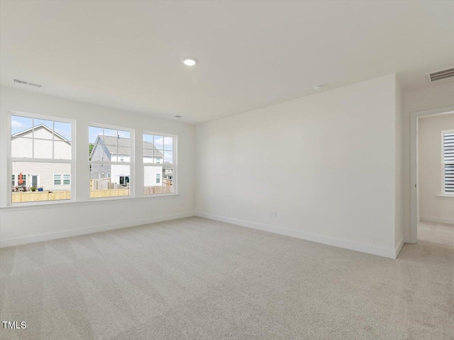 empty room with recessed lighting, visible vents, baseboards, and light colored carpet