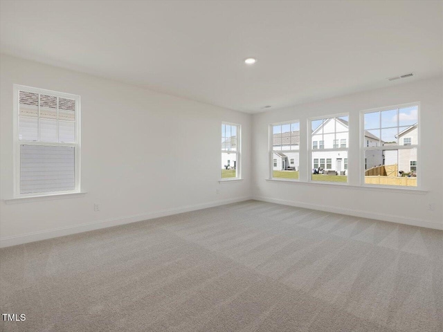 spare room with light carpet, visible vents, recessed lighting, and baseboards