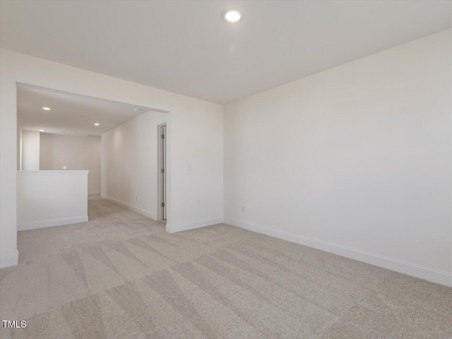 unfurnished room featuring recessed lighting, baseboards, and light carpet