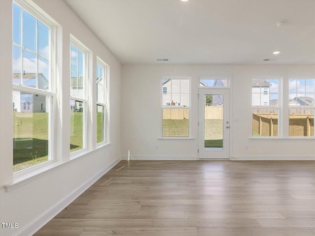 unfurnished sunroom featuring a healthy amount of sunlight and visible vents