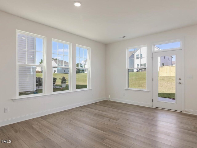 unfurnished room with visible vents, recessed lighting, wood finished floors, and baseboards