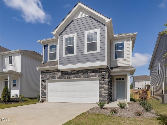 view of front facade featuring stone siding, an attached garage, and driveway