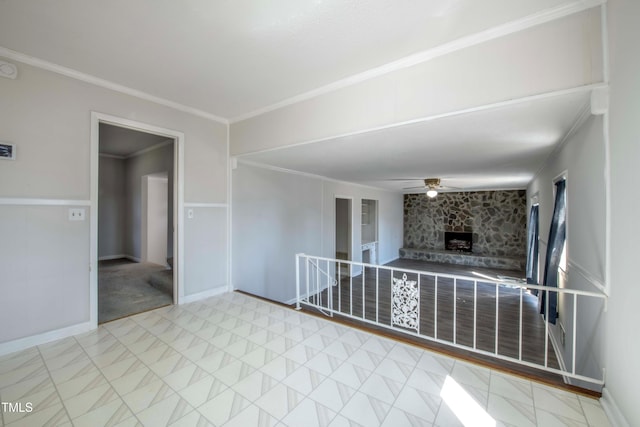 unfurnished living room with a ceiling fan, baseboards, a fireplace, crown molding, and marble finish floor